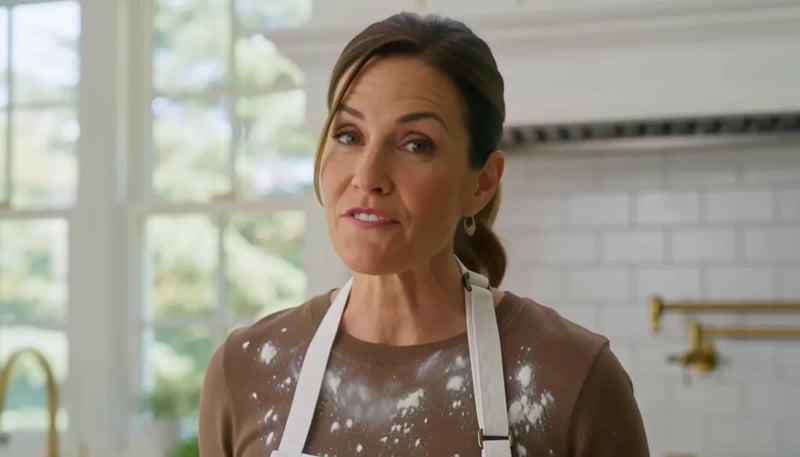 A chef speaks to camera in an open kitchen with a sizzle and an off-screen knife on a board — published MiniMax H3 Max demo